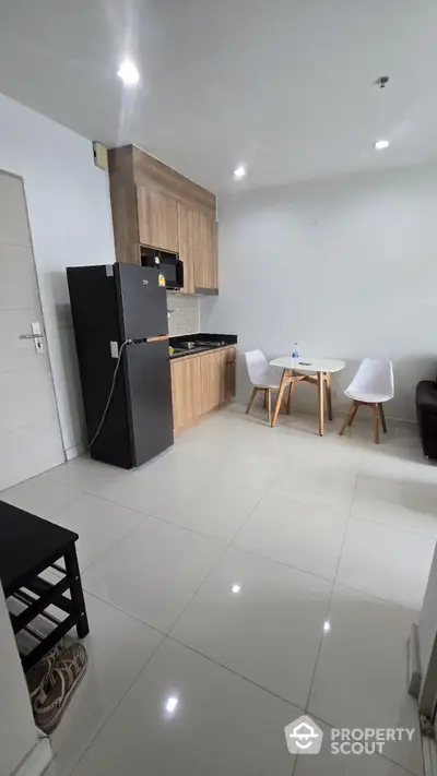 Modern kitchen with sleek cabinetry and dining area in contemporary apartment