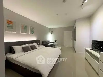 Modern bedroom with stylish decor and cozy seating area, perfect for relaxation.