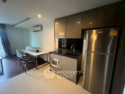 Modern kitchen with sleek appliances and cozy dining area in a stylish apartment.