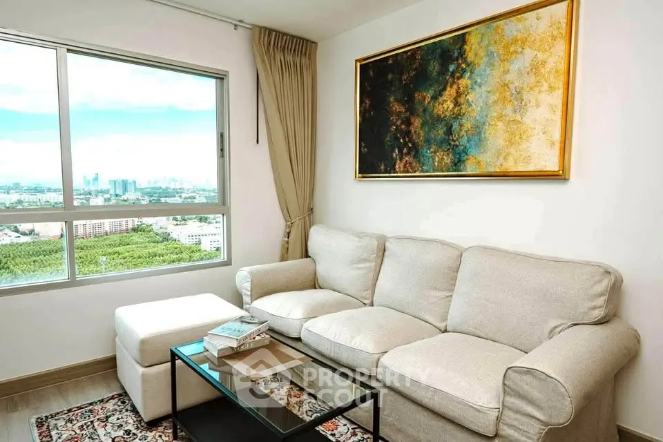 Bright living room with a cozy sofa, large window offering stunning city views, and elegant wall art.
