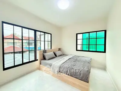 Bright minimalist bedroom with large windows and modern decor
