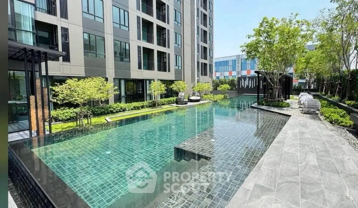 Luxurious modern apartment complex with stunning outdoor pool and lush greenery.