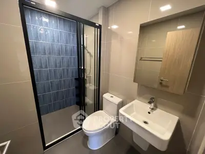 Modern bathroom with sleek design, featuring a glass shower enclosure and contemporary fixtures.