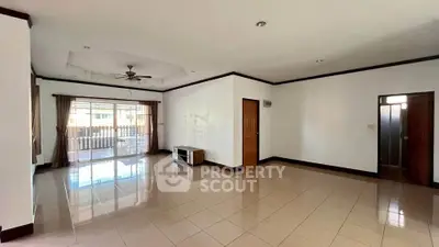 Spacious empty living room with large windows and ceiling fan