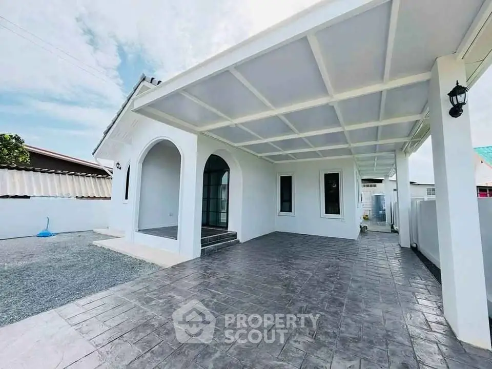 Charming white exterior with covered patio and arched entryway, perfect for modern living.