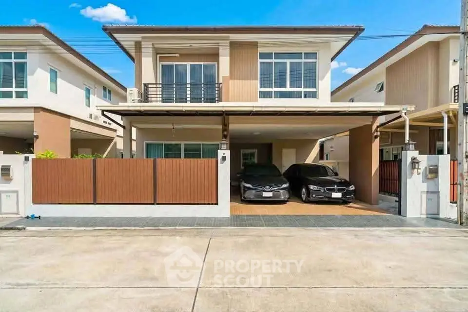 Modern two-story house with spacious driveway and two cars parked, showcasing contemporary architecture and design.