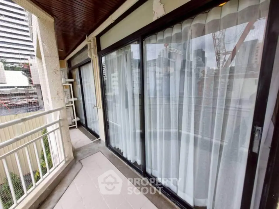 Spacious balcony with city view and sliding glass doors in urban apartment