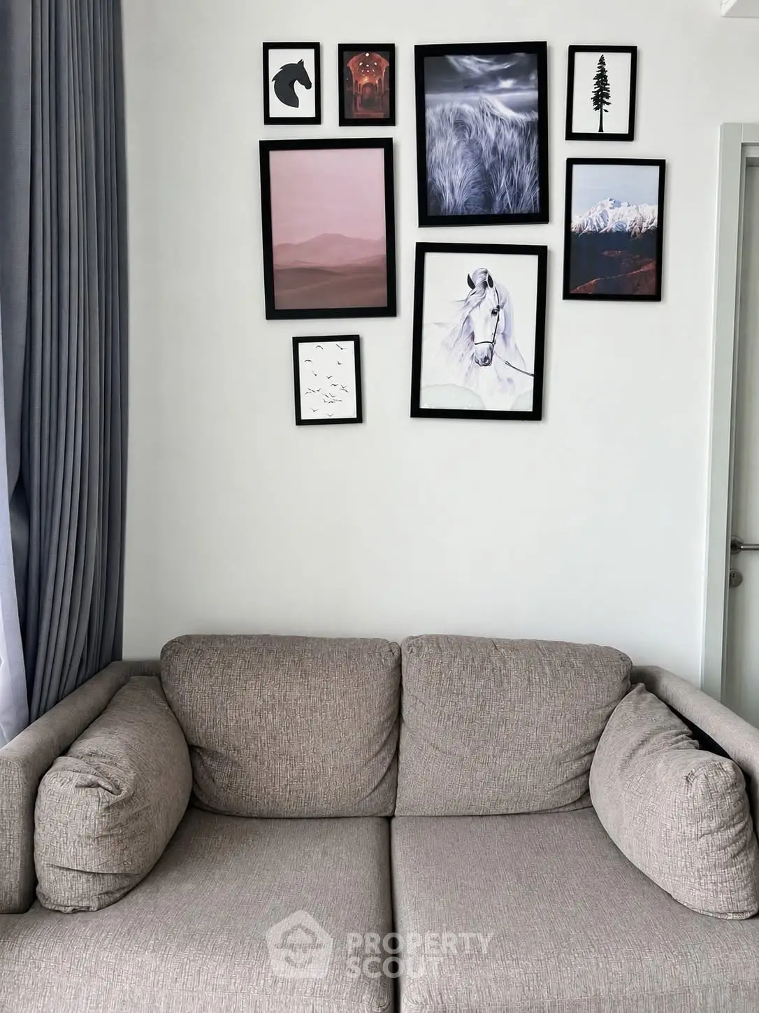 Stylish living room with modern art gallery wall and cozy gray sofa