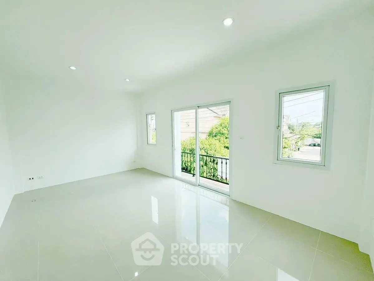 Spacious bright room with large windows and sliding doors opening to a balcony, perfect for natural light lovers.