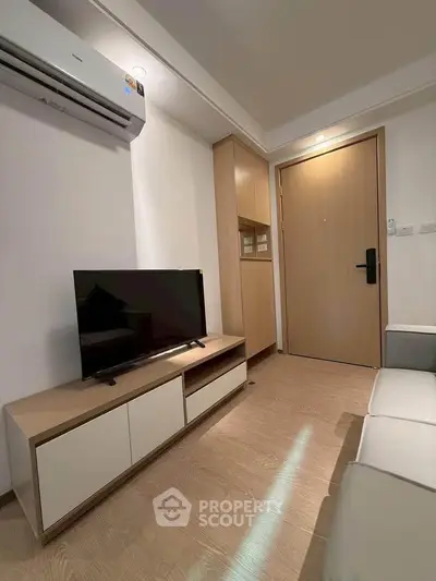 Modern living room with sleek TV unit and air conditioning, perfect for cozy relaxation.