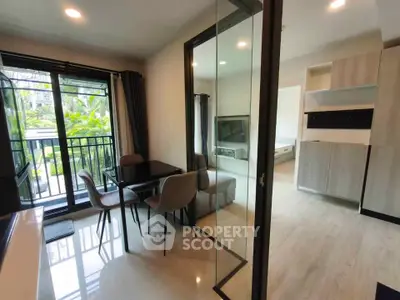 Modern open-layout living room with glass doors leading to a lush garden view balcony.