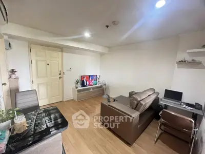 Cozy living room with modern furniture and TV, perfect for relaxation.