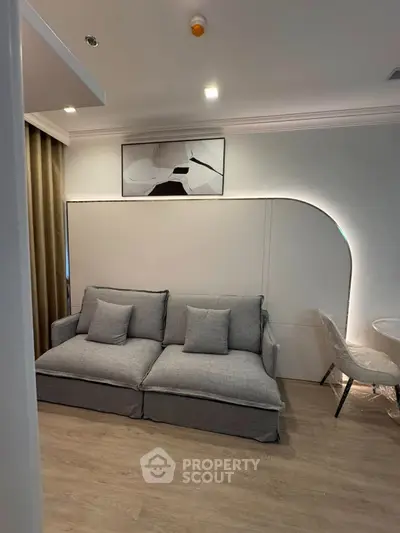 Modern living room with stylish gray sofa and elegant wall art, perfect for cozy relaxation.