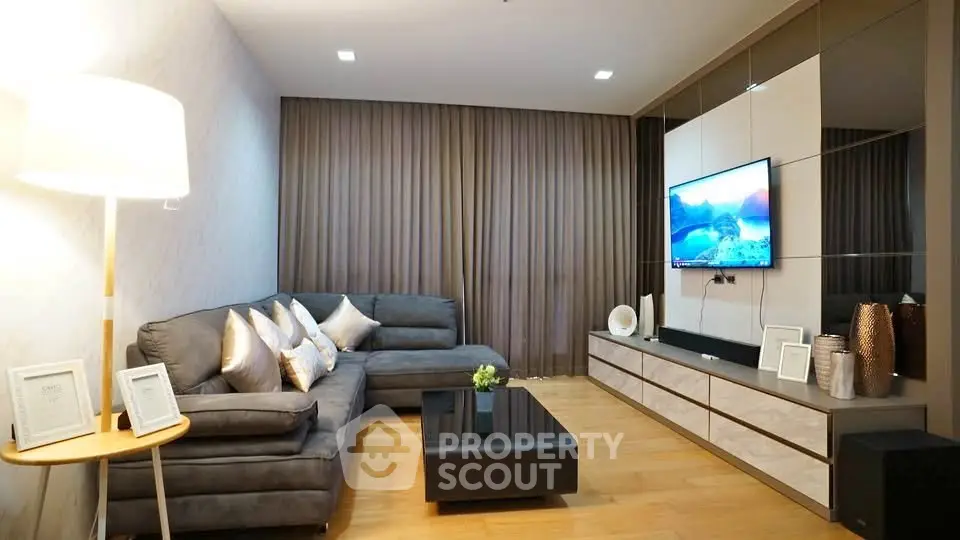 Modern living room with sleek furniture and stylish decor, featuring a cozy sectional sofa and wall-mounted TV.
