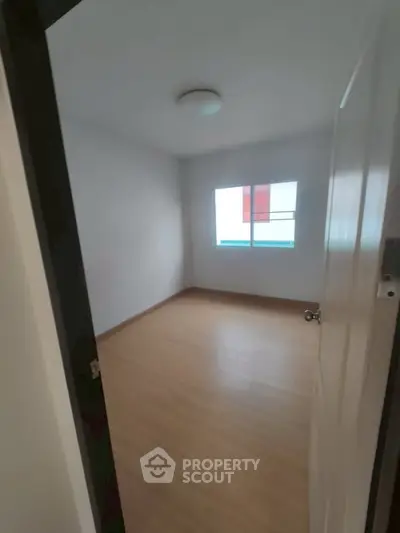 Spacious empty room with wooden flooring and natural light