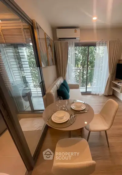 Modern living room with dining area and balcony view in stylish apartment.