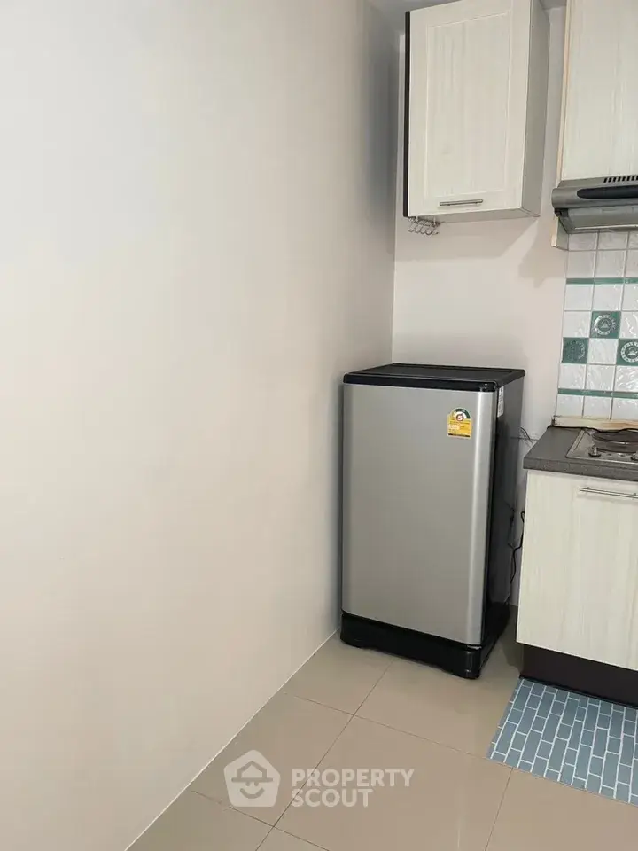 Compact kitchen corner with modern fridge and tiled backsplash