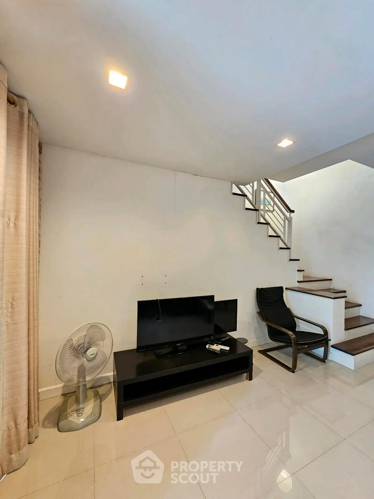 Modern living room with sleek staircase and minimalist decor