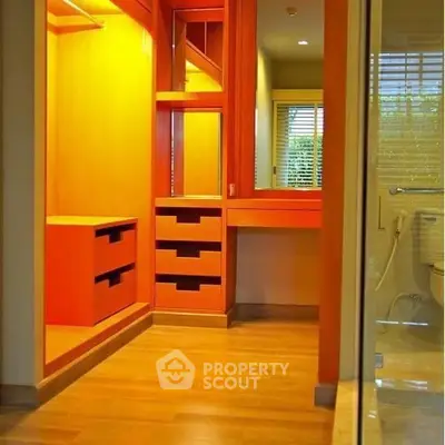 Spacious walk-in closet with wooden flooring and built-in storage
