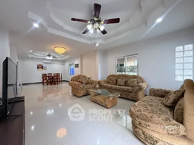Spacious living room with elegant ceiling fan and plush sofas in a modern home.