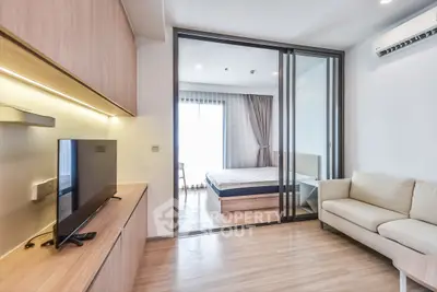 Modern studio apartment with sliding glass doors, cozy living area, and natural light.