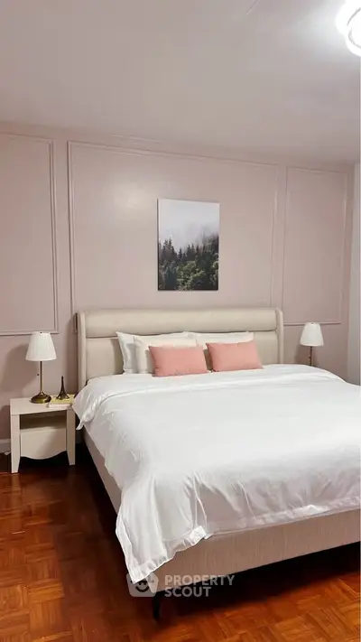 Elegant bedroom with plush bed, soft lighting, and serene wall art for a cozy retreat.
