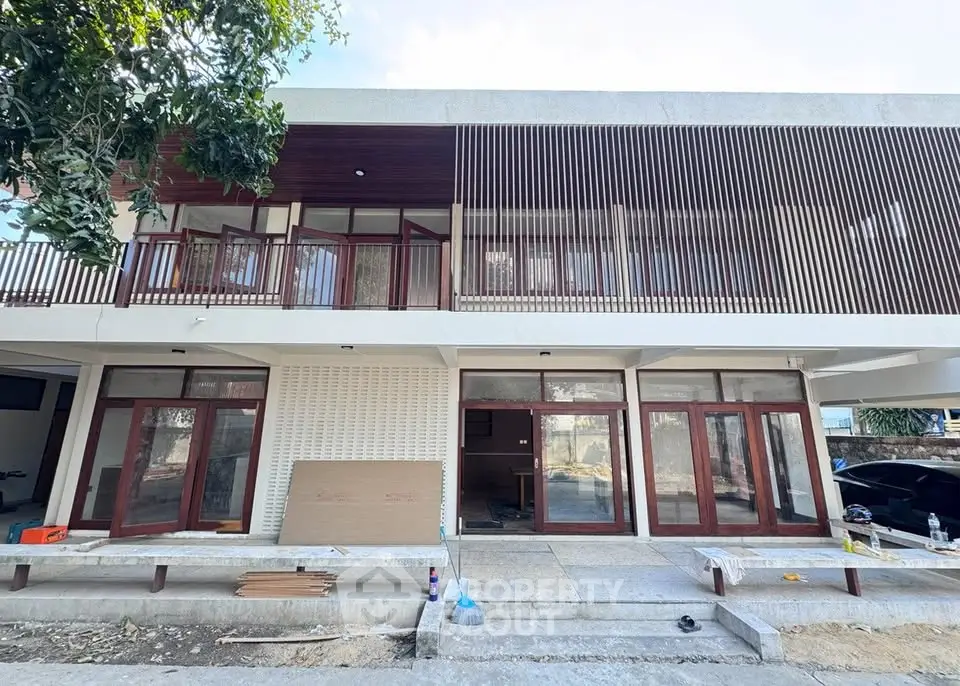 Modern two-story house with large windows and wooden accents, showcasing contemporary architectural design.