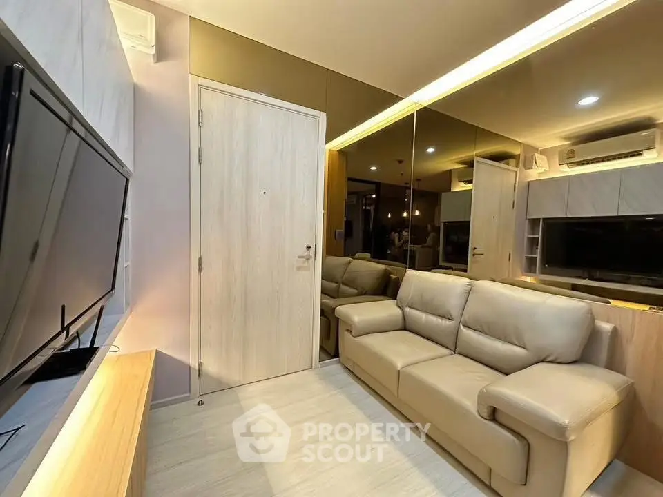 Modern living room with sleek design, featuring a comfortable sofa and large flat-screen TV, perfect for relaxation.