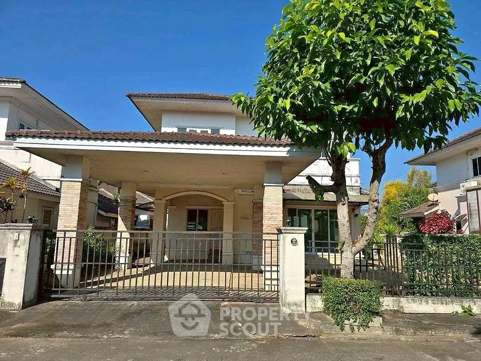 Charming two-story house with spacious driveway and lush greenery in a serene neighborhood.