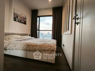 Modern bedroom with city view, featuring elegant decor and large window for natural light.
