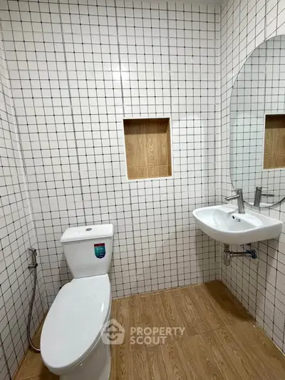 Modern bathroom with white tiled walls and wooden floor