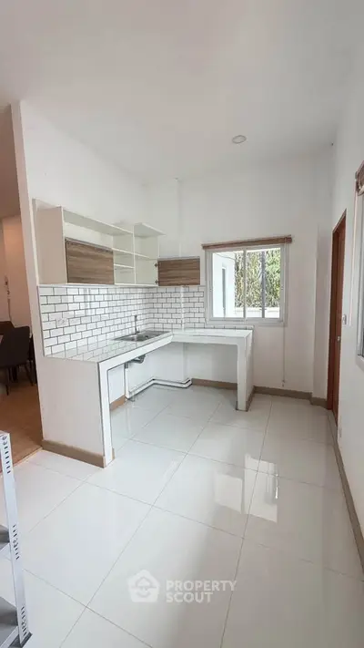 Modern kitchen with open layout and sleek white tiles