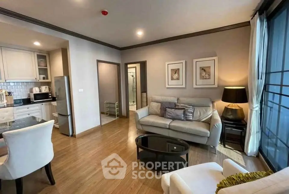 Modern living room with open kitchen, stylish decor, and cozy seating area in a contemporary apartment.