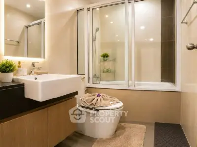Modern bathroom with sleek fixtures and elegant design, featuring a glass-enclosed bathtub and stylish vanity.