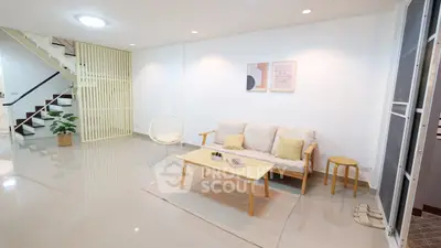 Modern living room with stylish decor and open staircase, perfect for contemporary living.