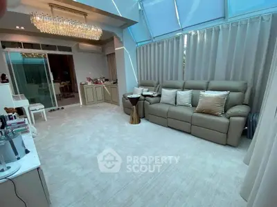 Luxurious living room with elegant chandelier and plush seating in modern home.