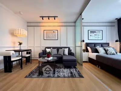 Modern open-plan living room with stylish decor and cozy bedroom area