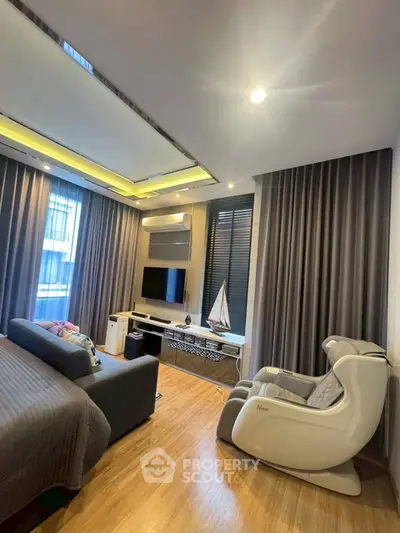 Luxurious modern living room with massage chair and sleek entertainment setup.