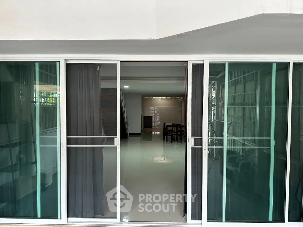 Spacious modern living area with glass sliding doors and sleek interior design.