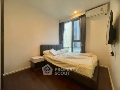 Modern bedroom with large window and cozy bed in stylish apartment.