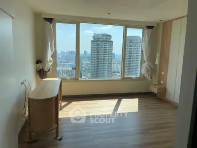 Spacious room with large windows offering stunning city skyline views, perfect for urban living.