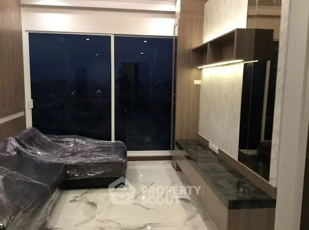 Luxurious living room with marble flooring and city view from large window.