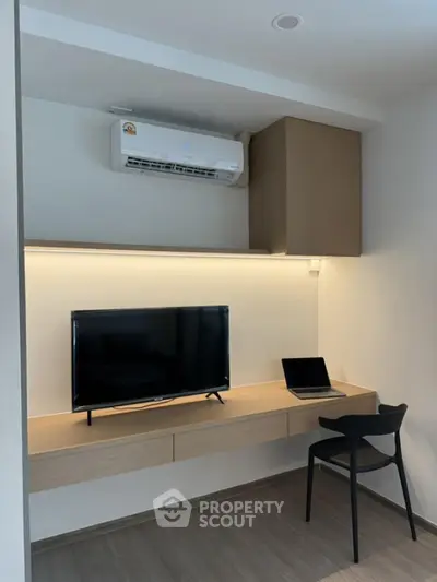 Modern study area with built-in desk, TV, and air conditioning