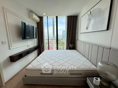 Modern bedroom with large window and city view, featuring stylish decor and mounted TV.
