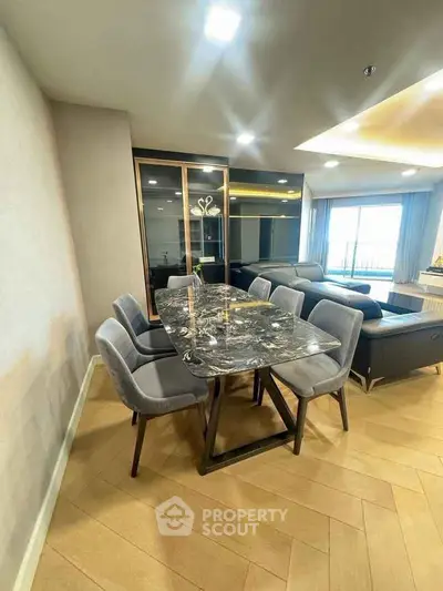 Luxurious modern dining area with marble table and elegant chairs in open-plan living space.