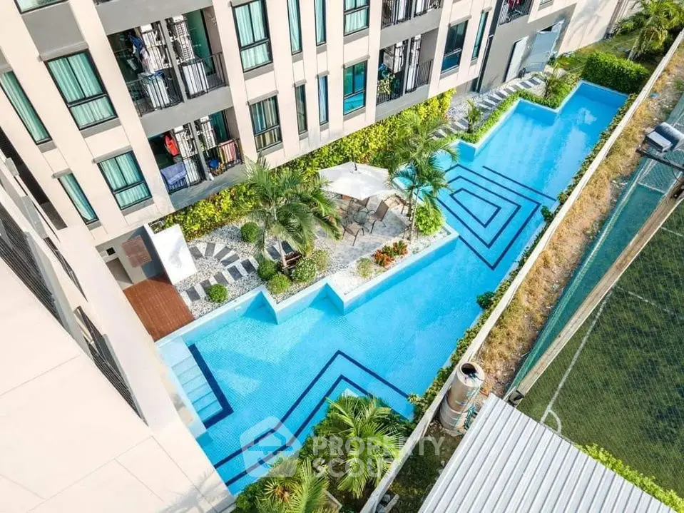 Luxurious apartment complex with stunning outdoor pool and lush greenery.