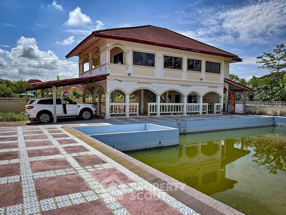 Stunning two-story villa with spacious pool area and elegant architecture under a clear blue sky.