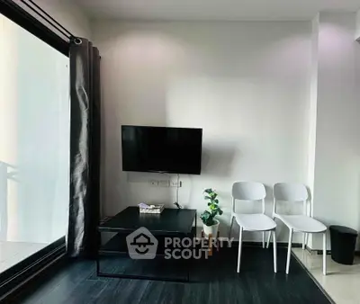 Modern living room with sleek black furniture and large window for natural light.