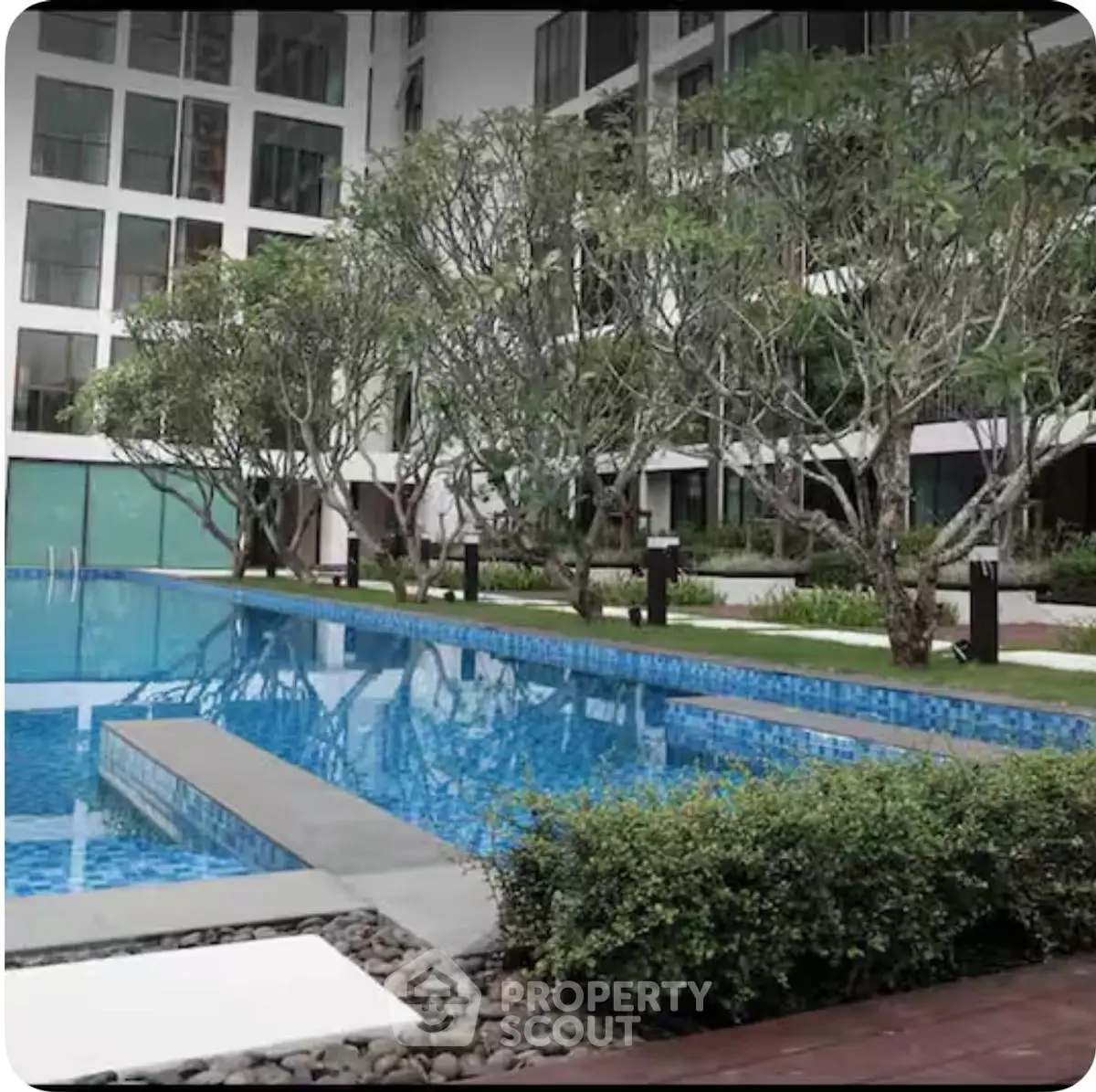 Luxurious apartment complex with stunning pool and lush greenery