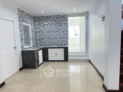 Spacious kitchen with modern mosaic backsplash, sleek marble countertops, and ample natural light, perfect for culinary enthusiasts.